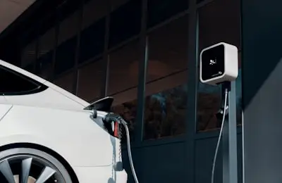 Laddbox monterad på vägg i ett garage med en elbil inkopplad.